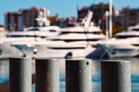 Focused iron bars in the seaport, with unfocused boats on backgroundの写真素材