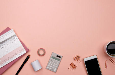 Office table desk with smartphone and other office supplies on pink background. Top view with copy space, flat lay.の写真素材