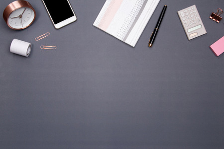 Office table desk with smartphone and other office supplies on grey background. Top view with copy space, flat lay.の写真素材
