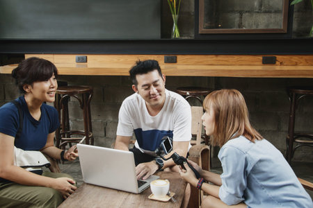 Cheerful male and female blogger discussing ideas for new project, brainstorming and checking video...