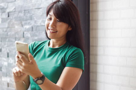 Young female holding smartphone and reading content in social network. Copy space, Selective focus.の写真素材