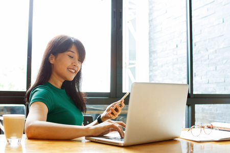 Asian young owner business woman working online, checking mail on laptop organizing working process in office. Copy space.の写真素材