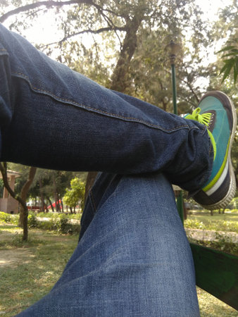 man relaxing and legs crossed in the park