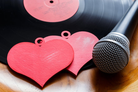 Song for lovers. Nostalgic songs, concept with vinyl records, microphone and hearts.
