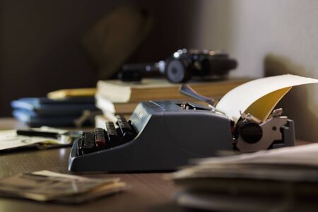 Vintage typewriter with blank paper sheet, documents, diary. Writer or editor in vintage office concept.の写真素材