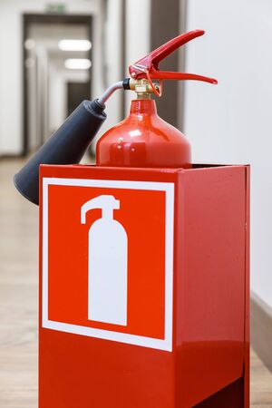 Fire extinguisher in empty white corridor. Office buildingの写真素材