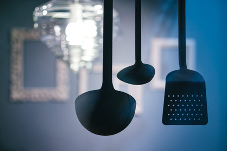 kitchen utensils hanging on a blue interior background.