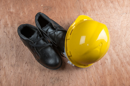 Yellow hard hat and leather boots, protective equipment in construction industry.の写真素材