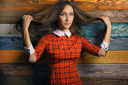 Portrait of Young Hipster Woman student in red dress on colorful Wooden Wall Backgroundの写真素材