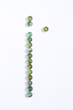 Line of colored marbles with one stands outの写真素材