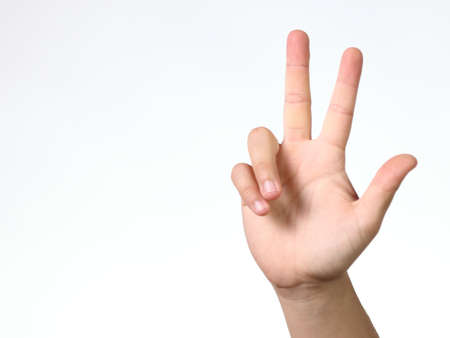 three fingers - a child's hand showing three fingers on a white backgroundの写真素材