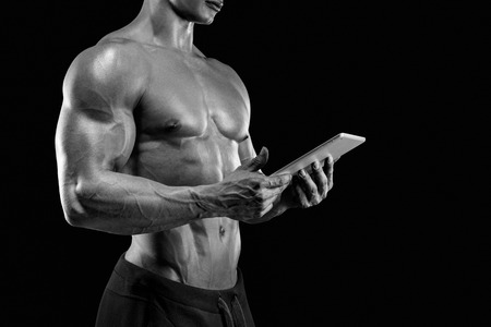 Close-up of Sporty and fit young man using a digital tabletの写真素材