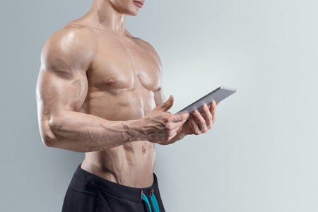 Close-up of Sporty and fit young man using a digital tabletの写真素材