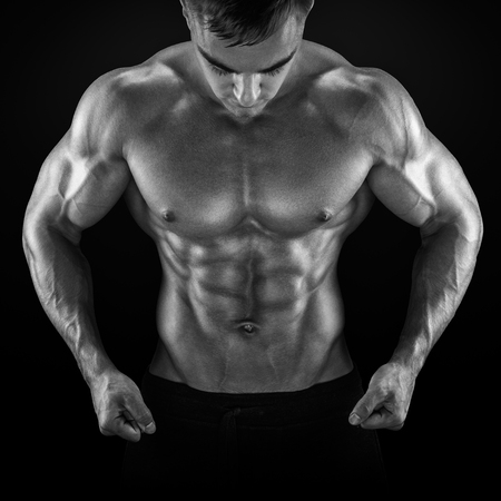 Strong athletic man fitness model torso showing six pack abs, perfect abs, shoulders, biceps, triceps and chest. Black and white photoの写真素材