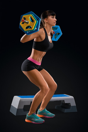 Portrait of beautiful fitness woman workout with barbell at gym. Perfect fit athletic young woman with six pack, perfect abs, shoulders, biceps, triceps and chest. Deadlift barbells workout.の写真素材