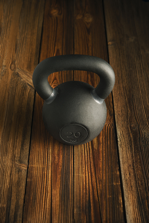 Top view of black iron kettlebell on wooden background Sport equipment background with copyspace Weight lifting exercise conceptの写真素材