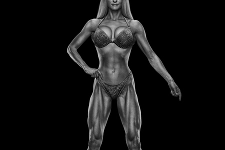 Cropped black white photo Fitness bikini model well trained body Sports competition female champion stage Athlete bodybuilder posing Perfect strong body trained shape arms abs chest legs Clipping pathの写真素材