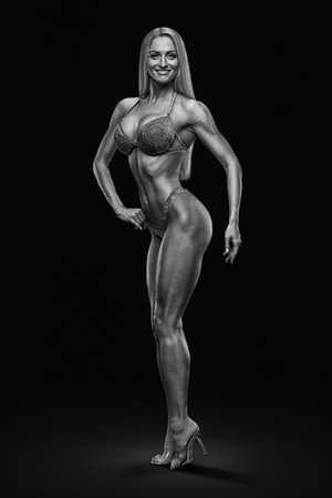 Black and white image inspire concept champion female fitness bikini model competition Confident attractive happy young bodybuilder looking forward Sports slim body perfect shape Black backgroundの写真素材