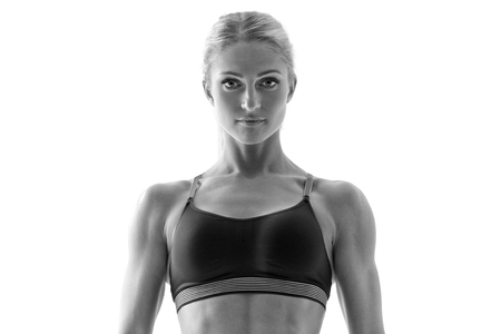 Black and white portrait of attractive strong healthy woman in sportswear posing looking at the camera with a serious expression Fitness and exercise conceptの写真素材