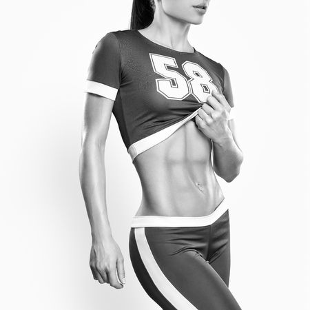 Fitness athletic young woman showing her well trained body, six pack, perfect abs, shoulders, biceps, triceps and chest, deltoid muscleの写真素材