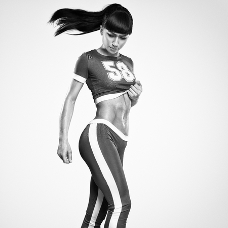 Fitness athletic young woman showing her well trained body, six pack, perfect abs, shoulders, biceps, triceps and chest, deltoid muscleの写真素材