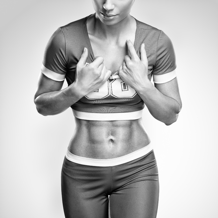 Fitness athletic young woman showing her well trained body, six pack, perfect abs, shoulders, biceps, triceps and chest, deltoid muscleの写真素材