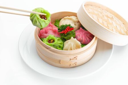 Dim sum Chinese in bamboo chopsticks close up photo on white background.の写真素材