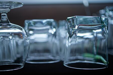 Clean washed and polished bar and pub glasses hanging over. Close-up photo of rows of empty glasses on the showcase Empty clean bar glasses backgroundの写真素材