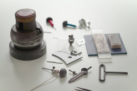 Various engraver goldsmith tools and object on white desk. Professional engraver tools for jewelleries gold platinum manufacturing Craftsman engraver jewellers workplace concept Light backgroundの写真素材