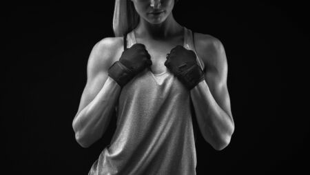 Black and white close up photo of fitness athletic young woman in sports top tank showing her well trained body, six pack, perfect abs, shoulders, biceps, triceps and chest, deltoid muscle.の写真素材
