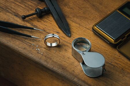 Jewelry craftsmanship desk. Golden engagement ring with diamondsの写真素材