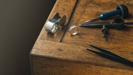 Jewelry craftsmanship desk. The jeweller engraver tools and golden diamonds ringの写真素材