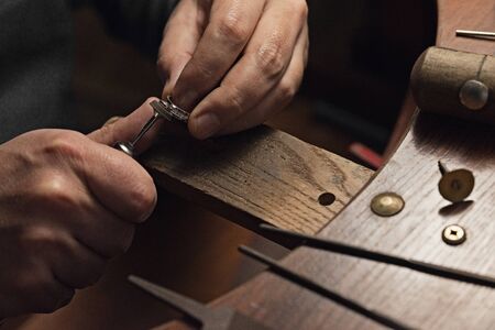 Jewelry craftsmanship. Handmade. Jeweler at work. The jeweler polishes a white gold ring with diamonds. Desktop with work tools.の写真素材