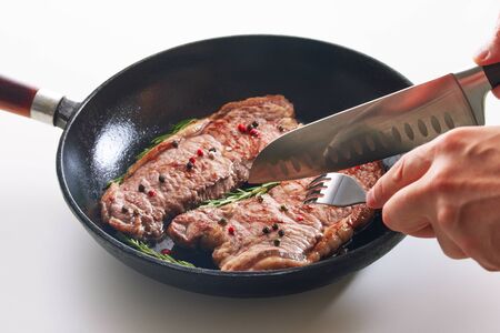 Concept for a tasty and healthy meal. Gourmet cuts into small pieces cooked for dinner steak of beef. Seasoned with spices and a sprig of rosemary.の写真素材