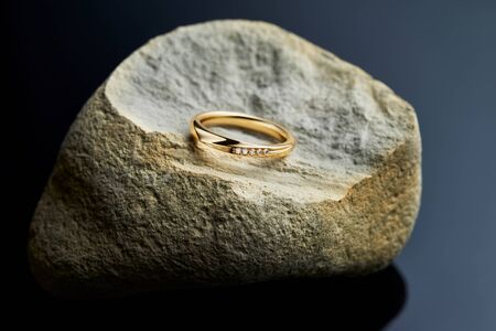 Womens engagement gold ring with diamonds on the stone, black backgroundの写真素材
