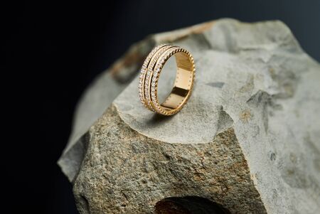Womans gold ring with diamonds on the stone, black backgroundの写真素材