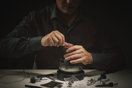 Engraver jeweller craftsman closeup. Focus on hands. Professional tools for jewelleries...