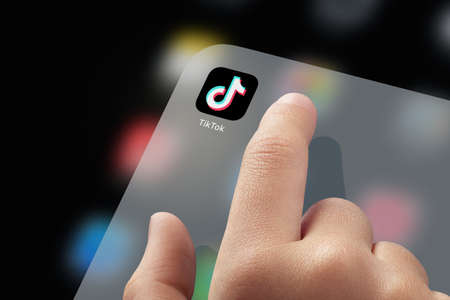 January 5, 2020, Kaliningrad, Russia. Close-up Child finger ready to click TikTok application icon on screen. TikTok is a very popular application video-sharing social networking serviceのeditorial素材