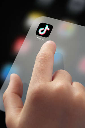 January 5, 2020, Kaliningrad, Russia. Close-up Child finger ready to click TikTok application icon on screen. TikTok is a very popular application video-sharing social networking serviceのeditorial素材