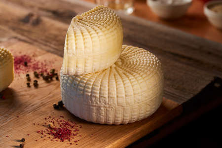Fresh homemade cottage cheese Feta cheese served with red peppers on vintage wooden board National Georgian cuisineの写真素材