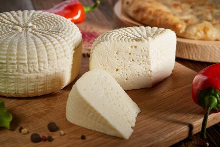 Feta Cheese Traditional cuisine feta cheese served with red peppers on vintage wooden board Closeup of round white homemade soft cheese - traditional milk creamy dairy product Fresh homemade cheeseの写真素材