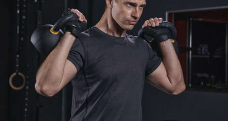 Cross fit training in a gym. Kettlebells swing exercise man workout at gym.の写真素材