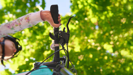 Bottom view teenage girl riding a bicycle on the road summer sunlitの写真素材