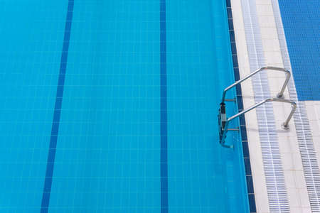 Swimming pool edge with a steel ladder Top view Empty sports swimming poolの写真素材
