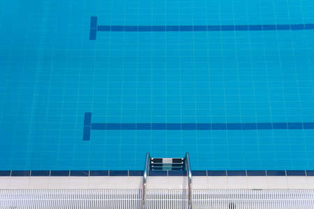 Swimming pool edge with a steel ladder Top view Empty sports swimming pool Horizontal orientationの写真素材