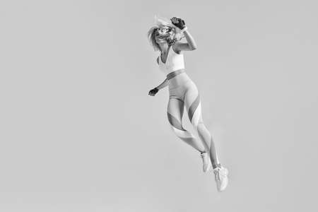 Happy sportswoman jumping and stretching.の写真素材