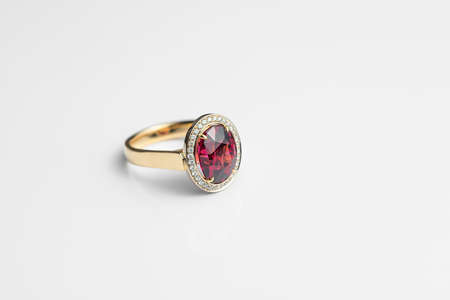 Beautiful expensive gold ring with rhodolite and diamonds on a white backgroundの写真素材