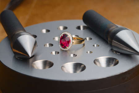 Luxury ring with ruby gemstone and bezel blocks on jewelers desktopの写真素材