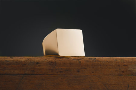 Empty signet ring on the edge of a wooden table on a dark background.の写真素材