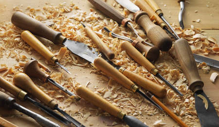 Woodworking cutters and shavings on a wooden table. Woodworkers desk. Wood carving process concept with free space on topの写真素材